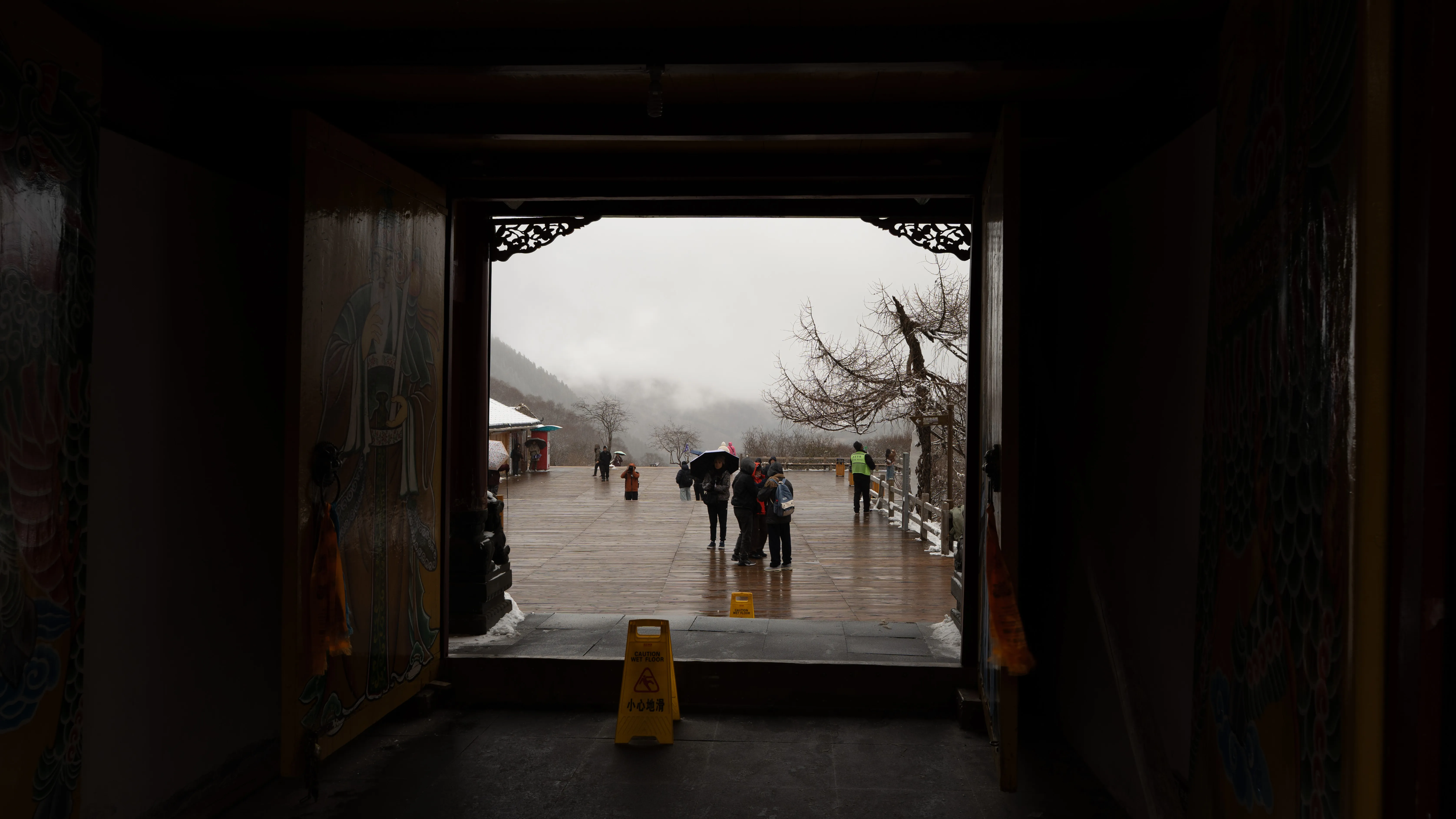 View through a temple gate toward the misted plaza