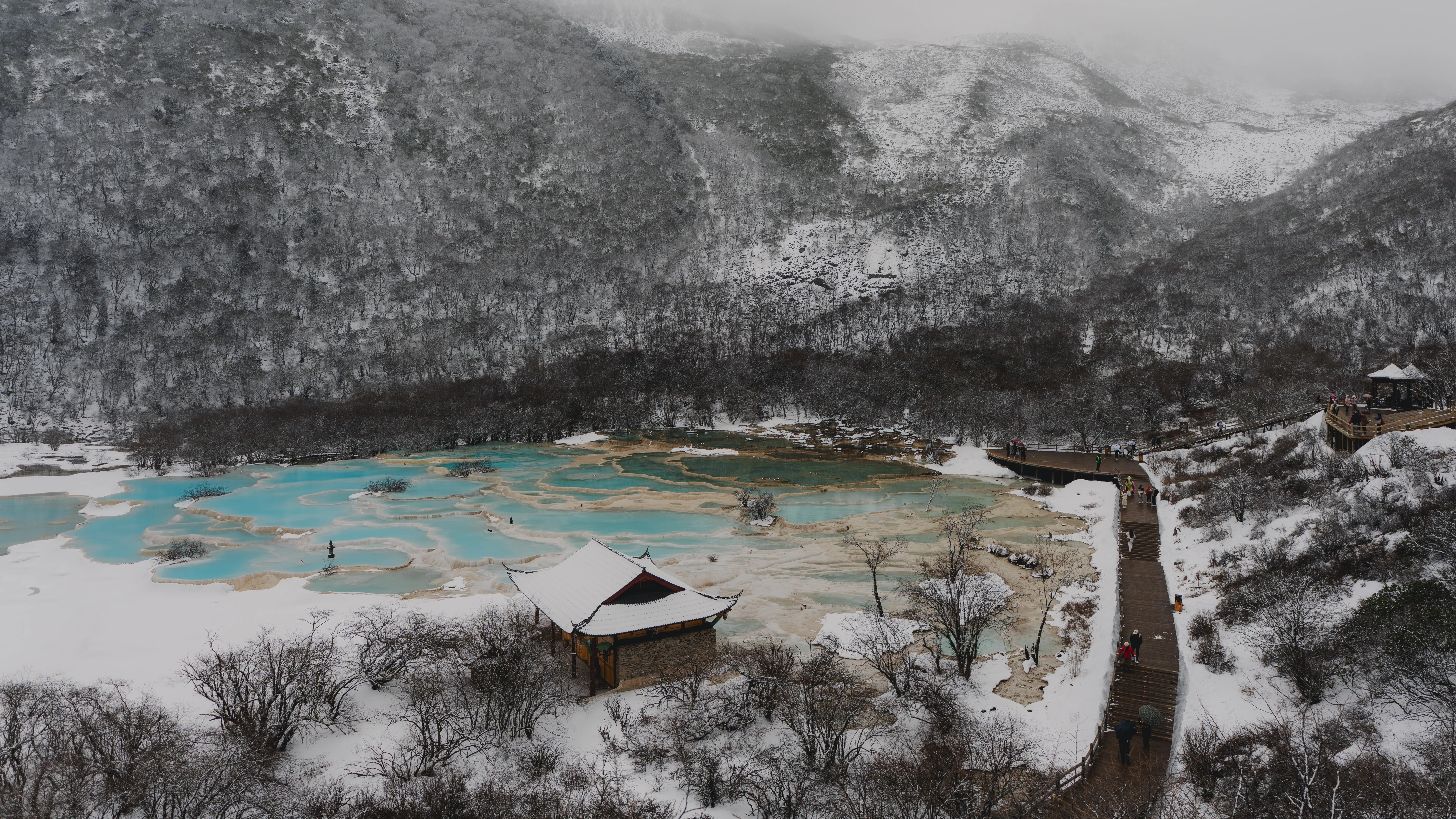 Turquoise mineral pools tucked below snow-dusted ridges