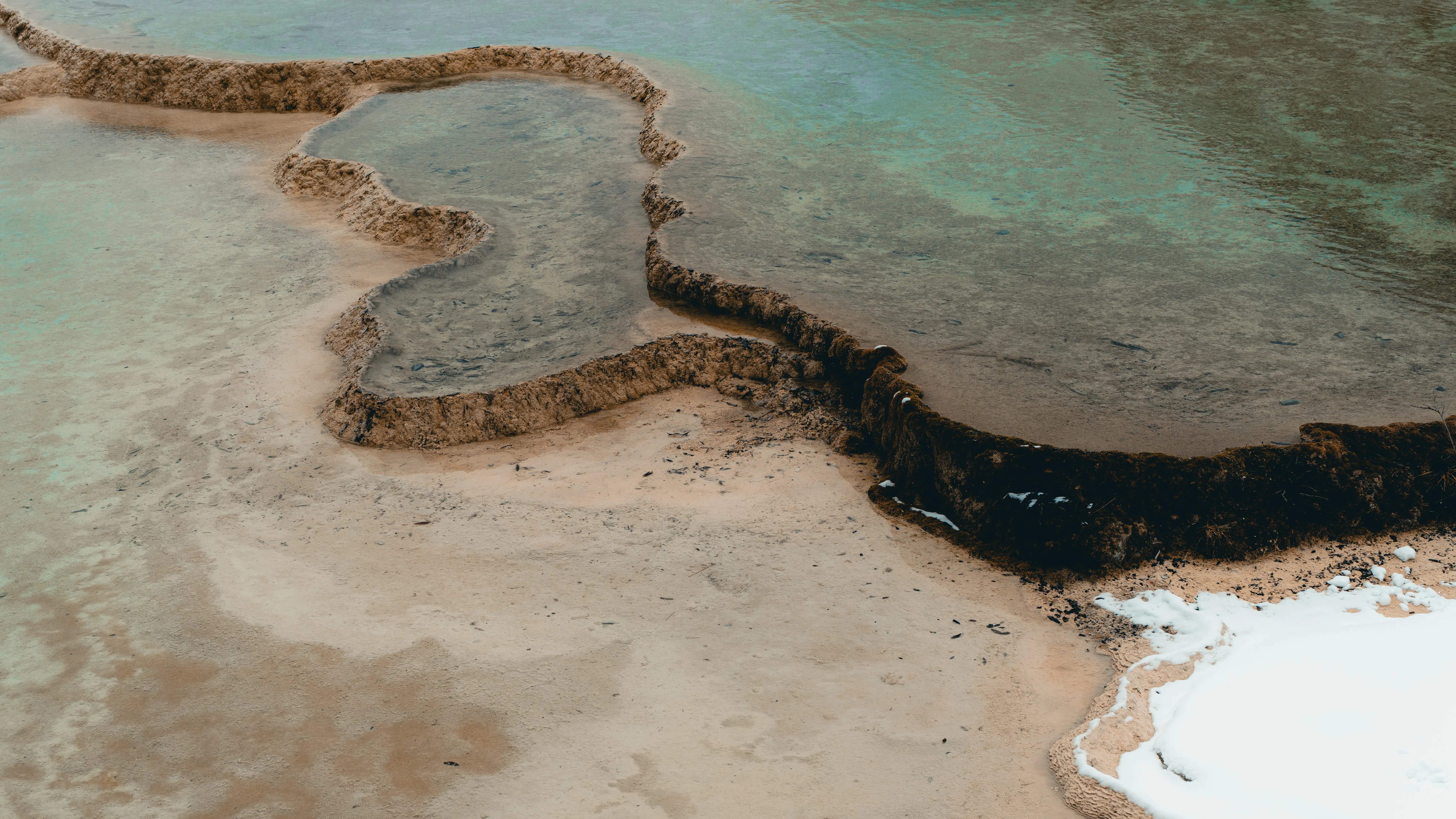 Shallow travertine terraces meeting open water
