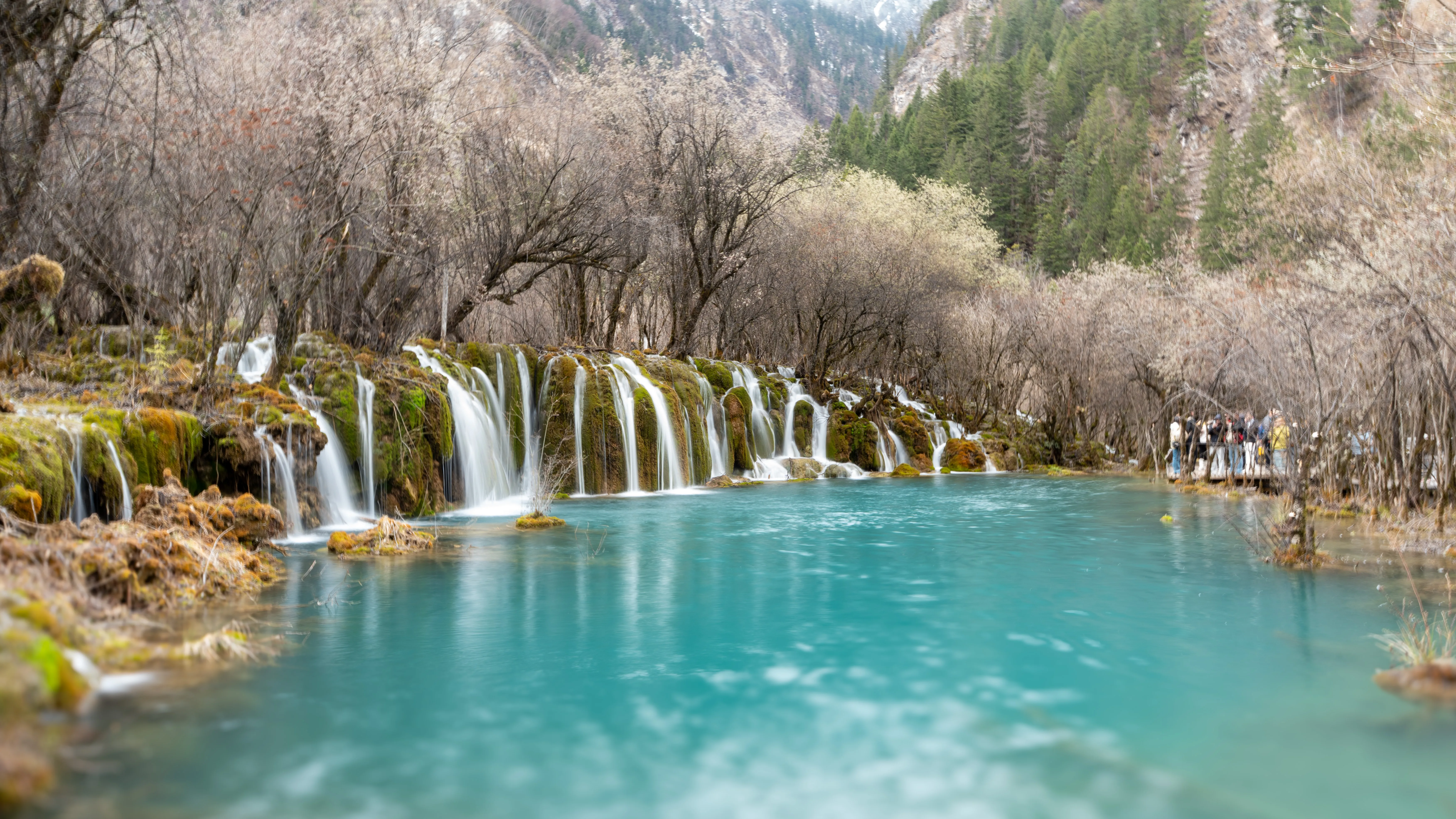 A wide falls spilling into turquoise shallows